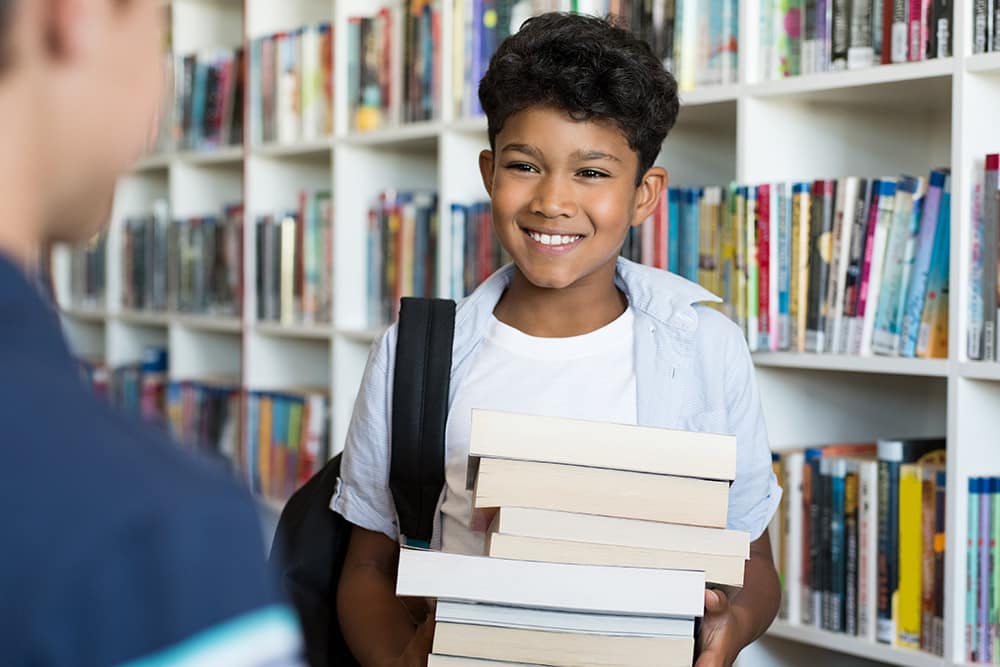 Boy with stack of books
